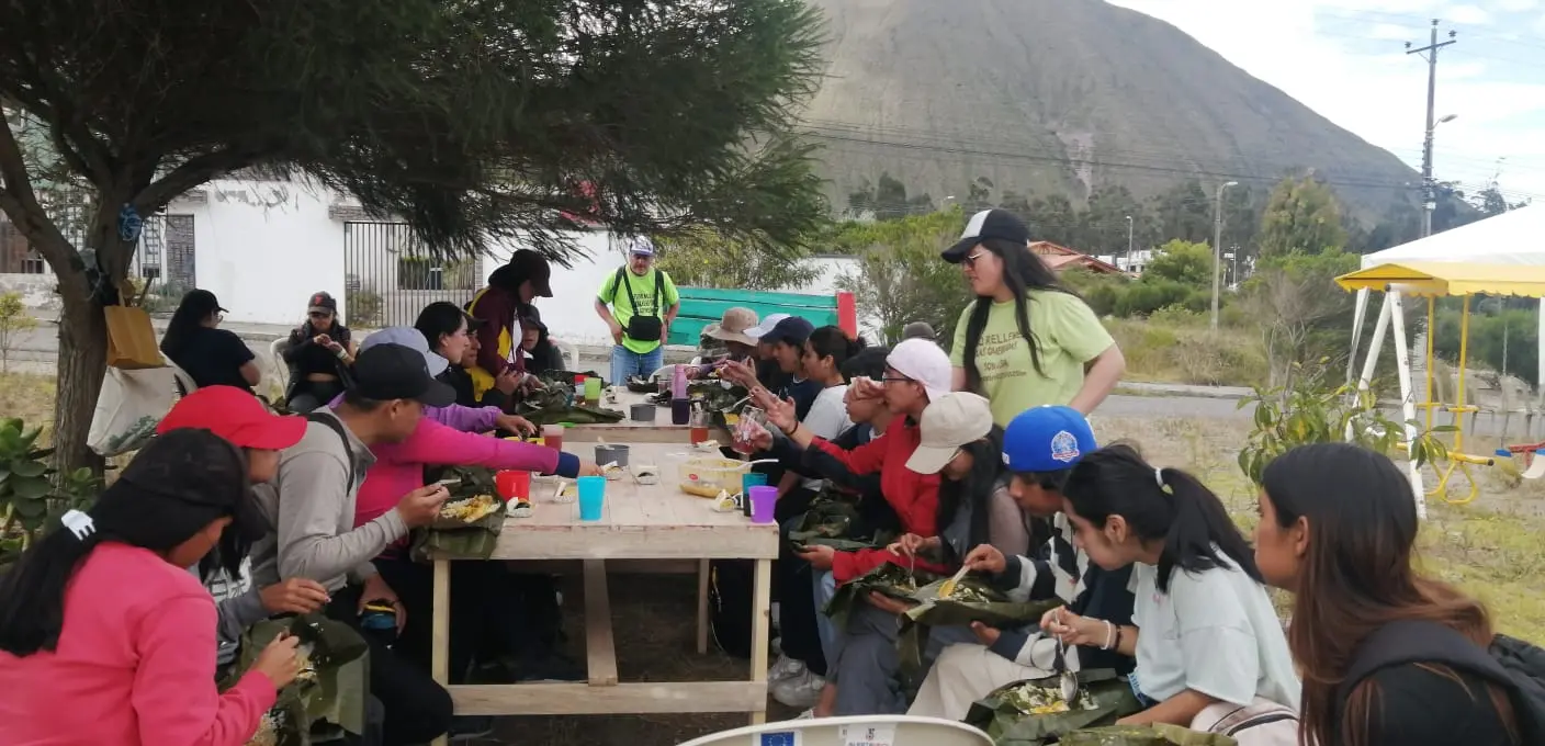 Participantes de Huayco Vivo compartiendo alimentos durante una jornada comunitaria al aire libre en Quito